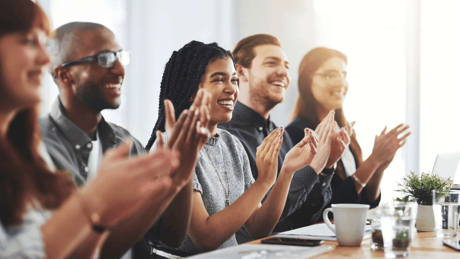 Employees clapping at a meeting