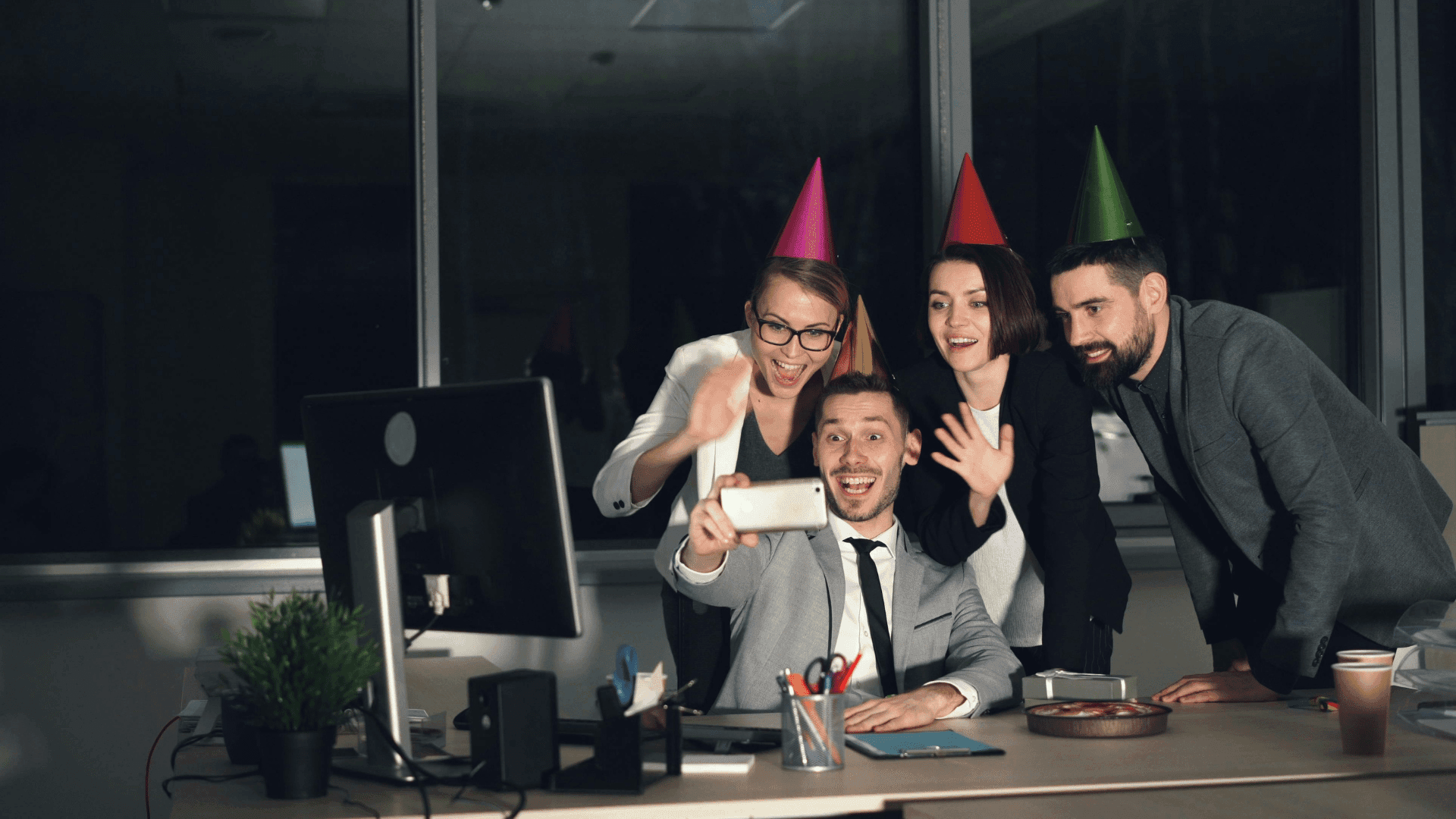 Office workers with party hats on a virtual call