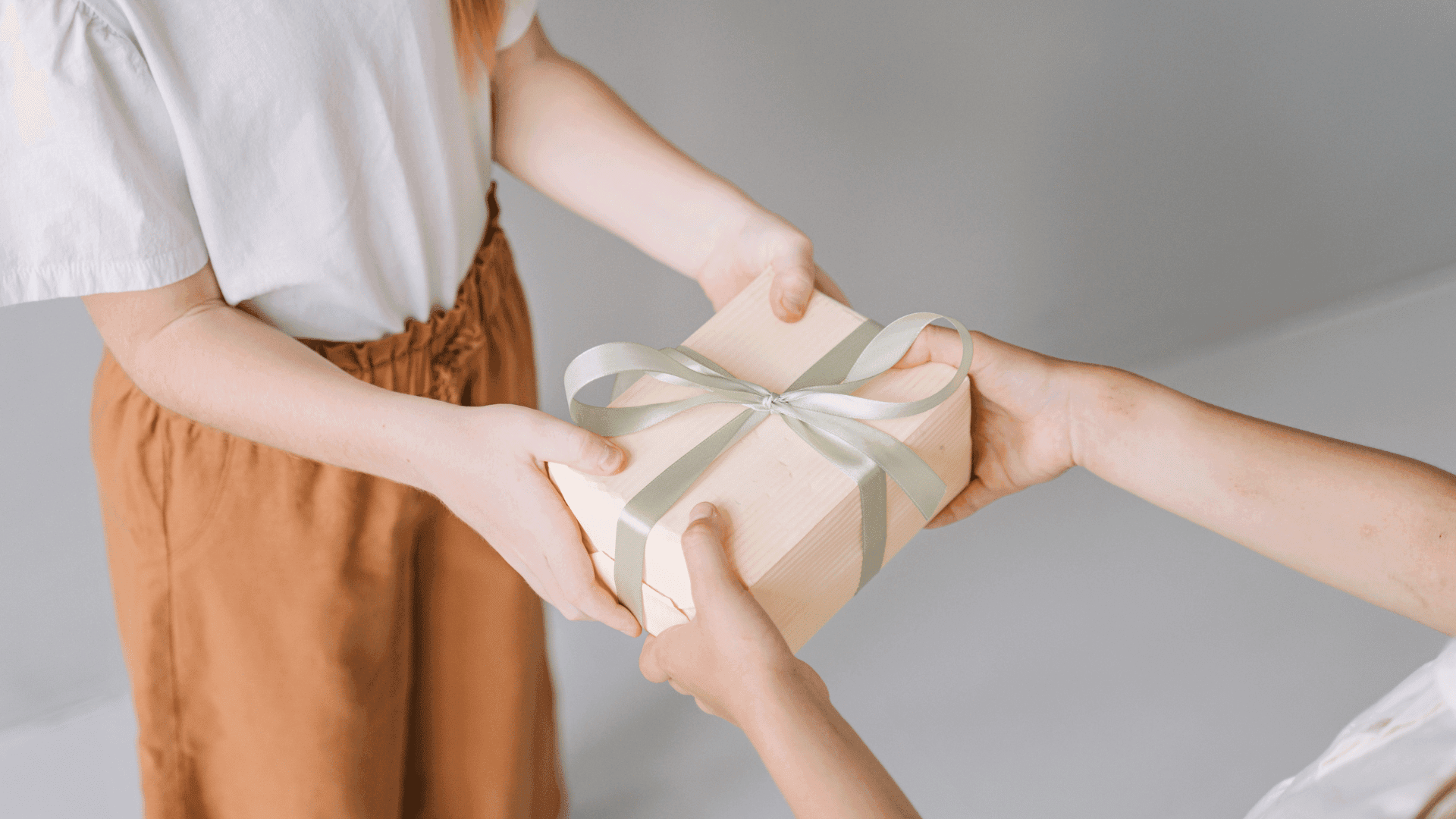 A person handing a gift to another person